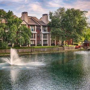 Serene view of fountain, waterfront gazebo and the lake against beautiful blue skies
